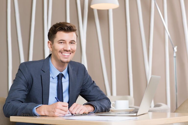 Happy Adult Businessman Working at Desk in Office